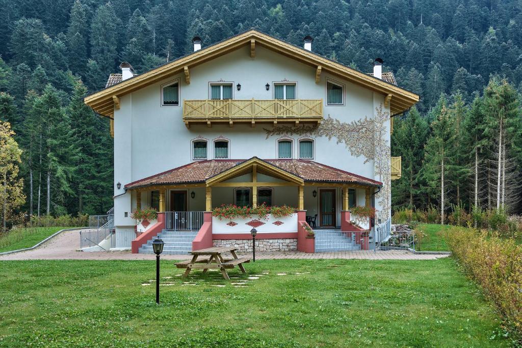 ein großes Haus mit einem Picknicktisch im Hof in der Unterkunft Genzianella Molveno-Andalo in Molveno