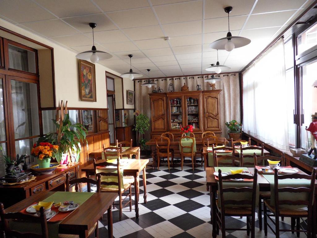 a restaurant with tables and chairs and a checkered floor at Hôtel Victoria in Grenoble