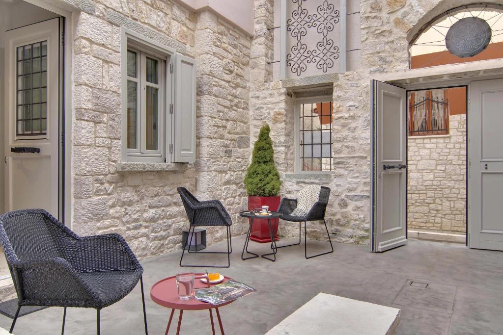 a patio with chairs and a table in front of a building at Hotel Boulgari in Ioannina