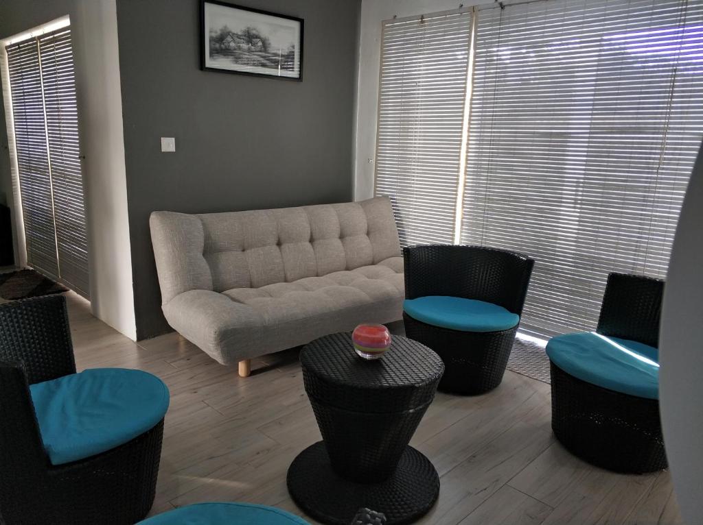a living room with a couch and some chairs at A1 Dittany of Crête in Grand-Baie