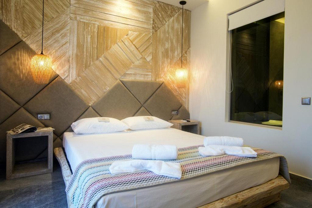 ein Schlafzimmer mit einem Bett mit zwei Handtüchern darauf in der Unterkunft Katrine Boutique Apartments in Kavala