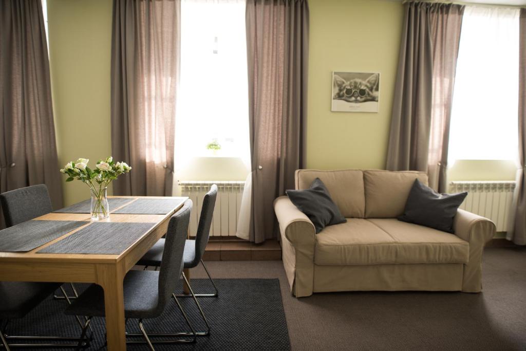 ein Wohnzimmer mit einem Tisch und einem Sofa in der Unterkunft Eliksyras Apartment in Vilnius