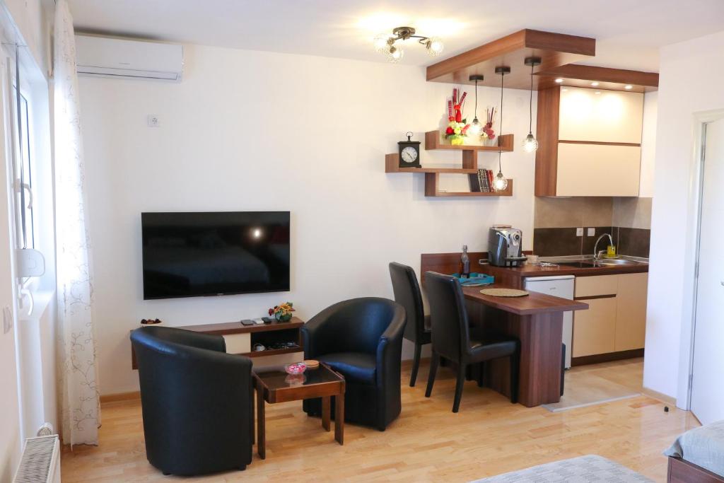 cocina y sala de estar con mesa y sillas en DM apartment, en Niš