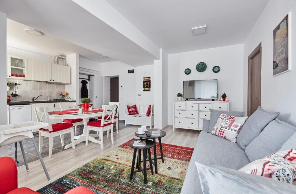 sala de estar y cocina con sofá y mesa en George Apartment Sinaia, en Sinaia