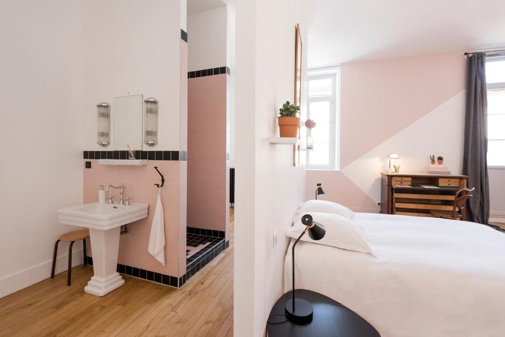 a white bedroom with a sink and a bed at La Maison d'Ambronay in Ambronay