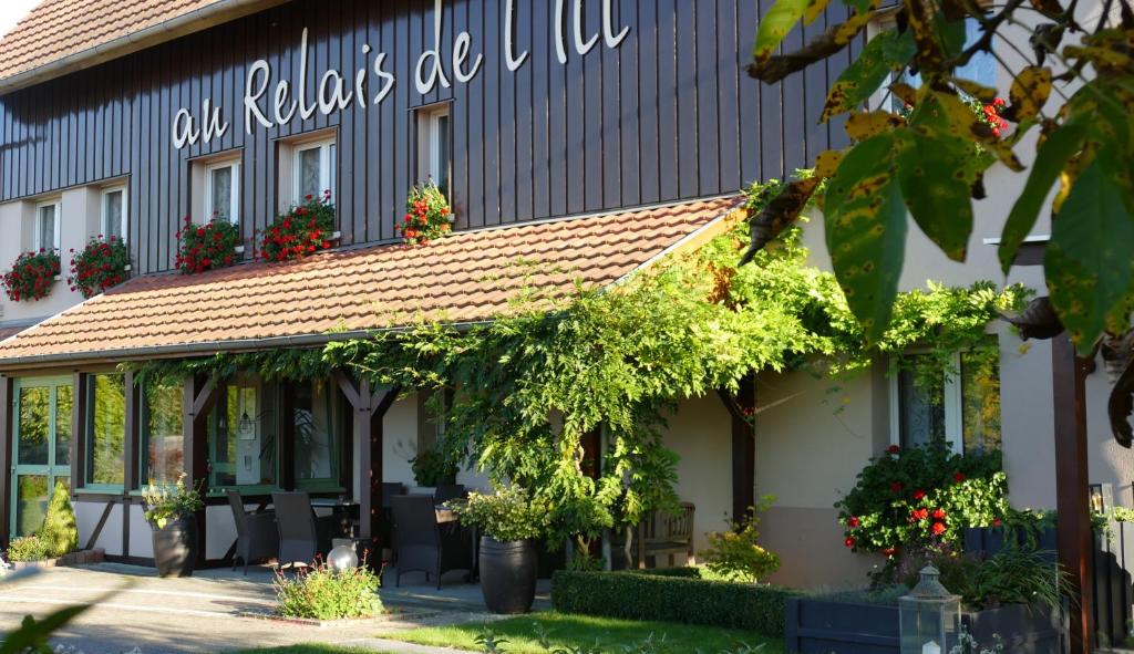 a building with a sign that reads our flowers are alive at Au Relais de l'Ill in Sermersheim