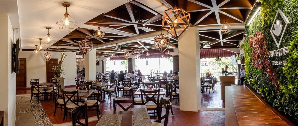 - un restaurant avec des tables et des chaises dans une salle dans l'établissement Hotel Mansur Business & Leisure, à Córdoba