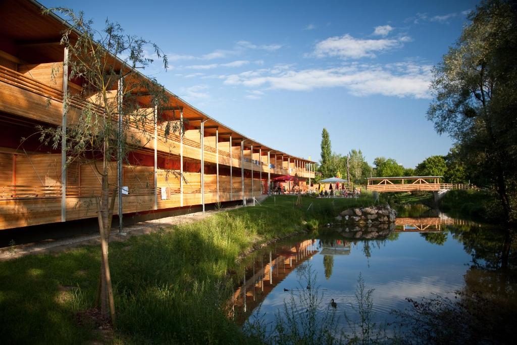 eine Brücke über einen Fluss neben einem Wasserkörper in der Unterkunft JUFA Hotel Leibnitz in Leibnitz