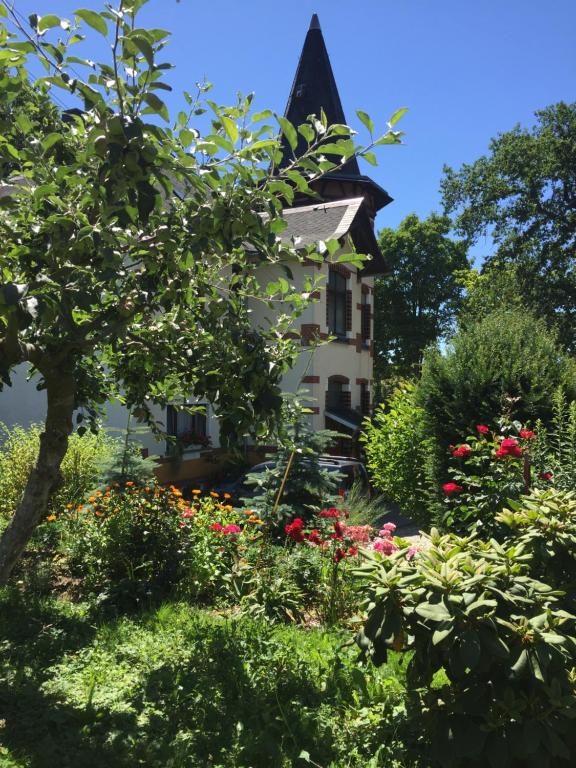 ein Haus inmitten eines Gartens mit Blumen in der Unterkunft Turmvilla Vogtland in Oelsnitz