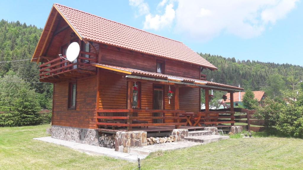 a small wooden cabin in the middle of a field at Hunor-Magor Vendégház in Izvoare