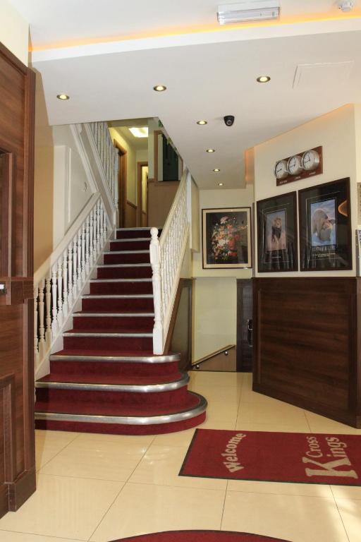 a staircase in a home with red and white carpet at Kings Cross Inn Hotel in London