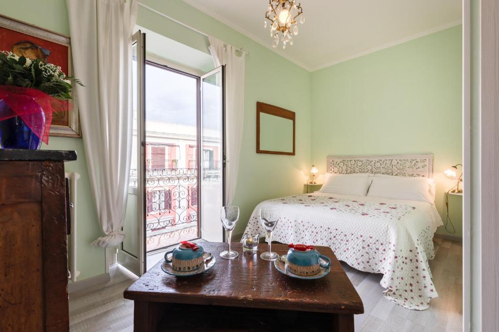 Un dormitorio con una cama y una mesa con gafas. en A Roman Tale B&B en Roma