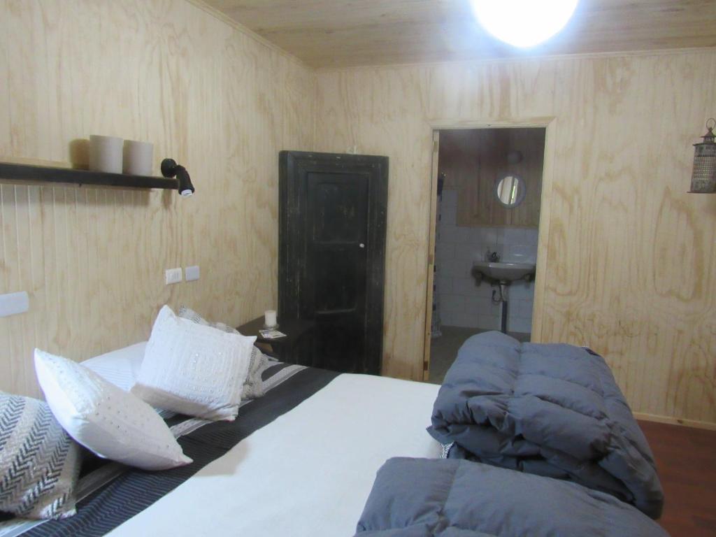 een slaapkamer met een bed en een stoel erin bij Centro Ecuestre Hipomedano in Casas Fundo El Médano