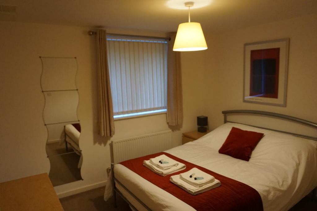 a bedroom with a bed with two towels on it at Brook Apartment in Bristol