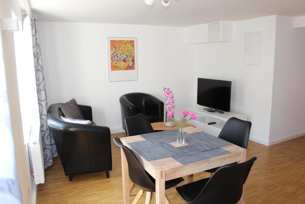 uma sala de jantar com uma mesa e cadeiras pretas em Inside Apartments Speyer em Speyer