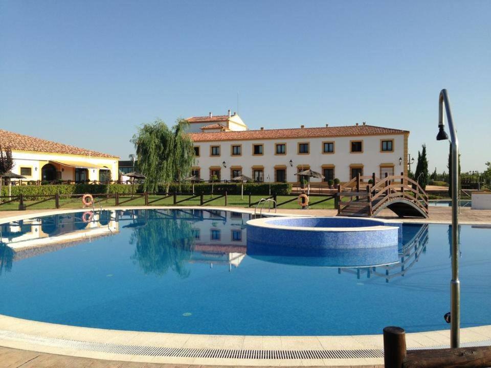 una gran piscina frente a un edificio en Hospedium Hotel Cortijo Santa Cruz, en Villanueva de la Serena