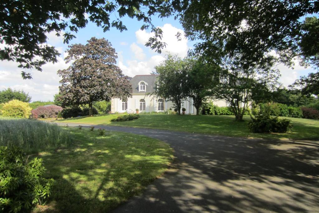 eine Auffahrt zu einem großen weißen Haus in der Unterkunft Gîte - Chambre d Hôtes Les 4 vents Guingamp in Saint-Agathon