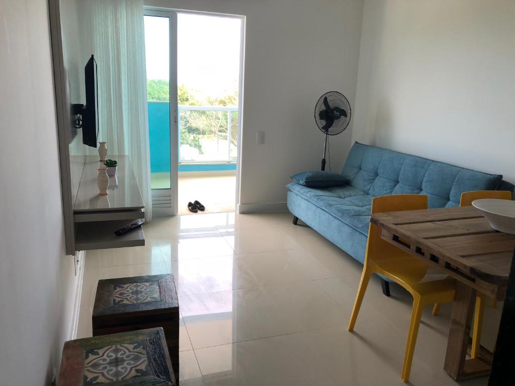 a living room with a blue couch and a table at Arraial do Cabo-Apartamento para temporada-Condomínio Golden Lake in Arraial do Cabo