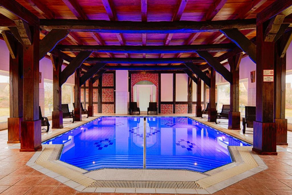 ein großer Pool in einem Gebäude mit großer Decke in der Unterkunft Schloss Herrenstein in Gerswalde
