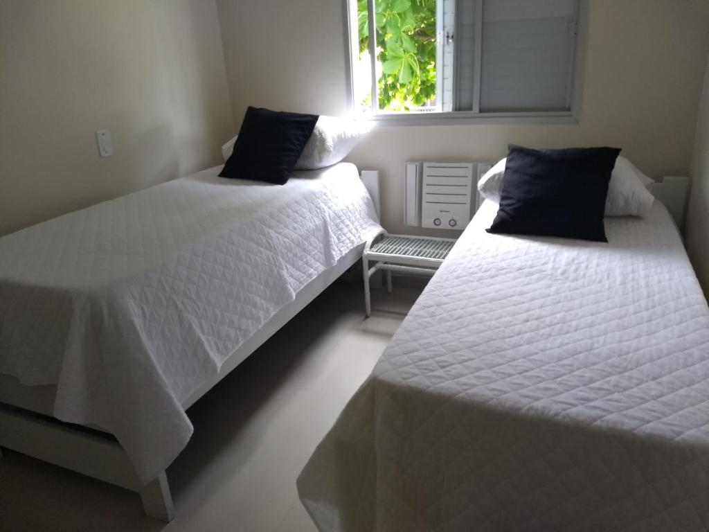 A bed or beds in a room at Apto Novo a uma Quadra da Praia