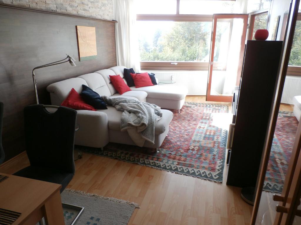 a living room with a white couch and a window at Bergsee in Schluchsee