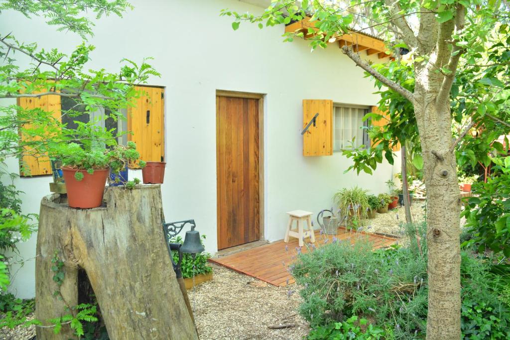 ein Haus mit einer Holztür und einer Terrasse in der Unterkunft La Casa de Huéspedes in Santa Teresita