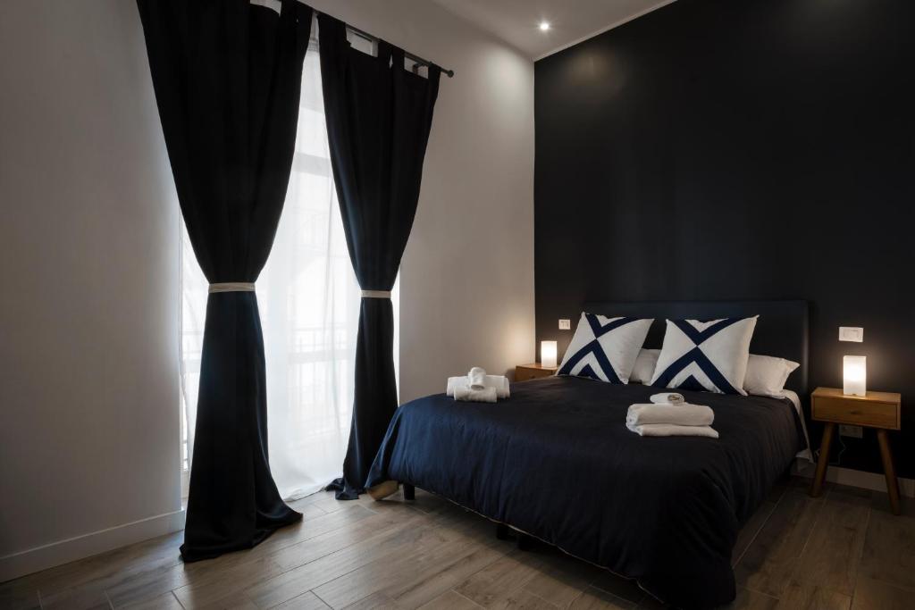 ナポリにあるSant'Alfonso Bed and Breakfast Napoliのベッドルーム1室(黒いカーテンと窓付きのベッド1台付)