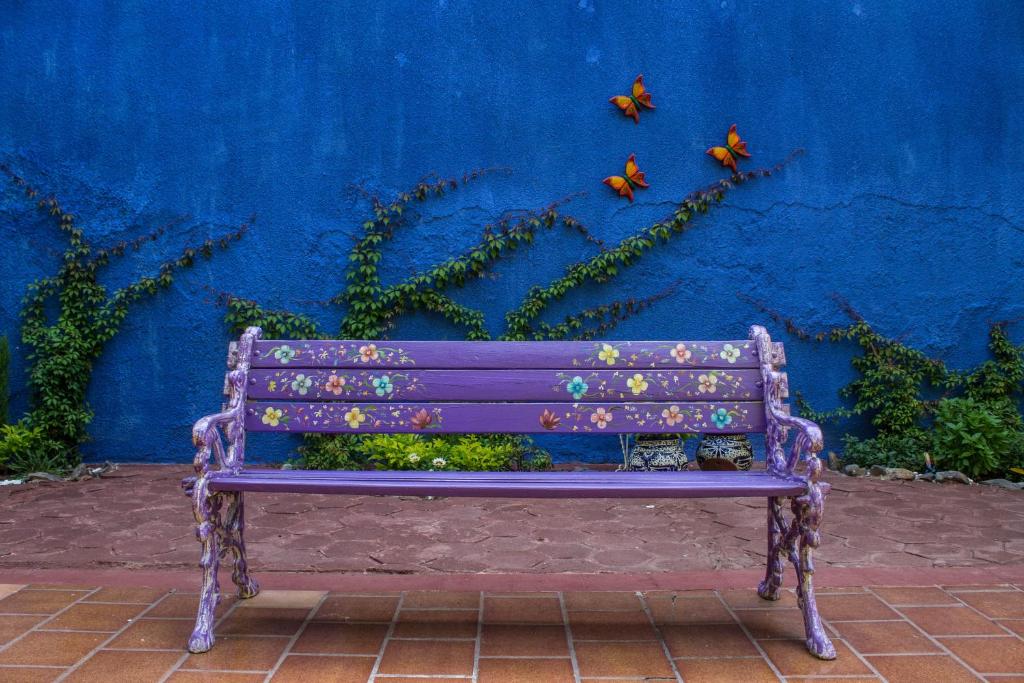 a purple bench sitting in front of a blue wall at Hostal Tlaquepaque in Guadalajara