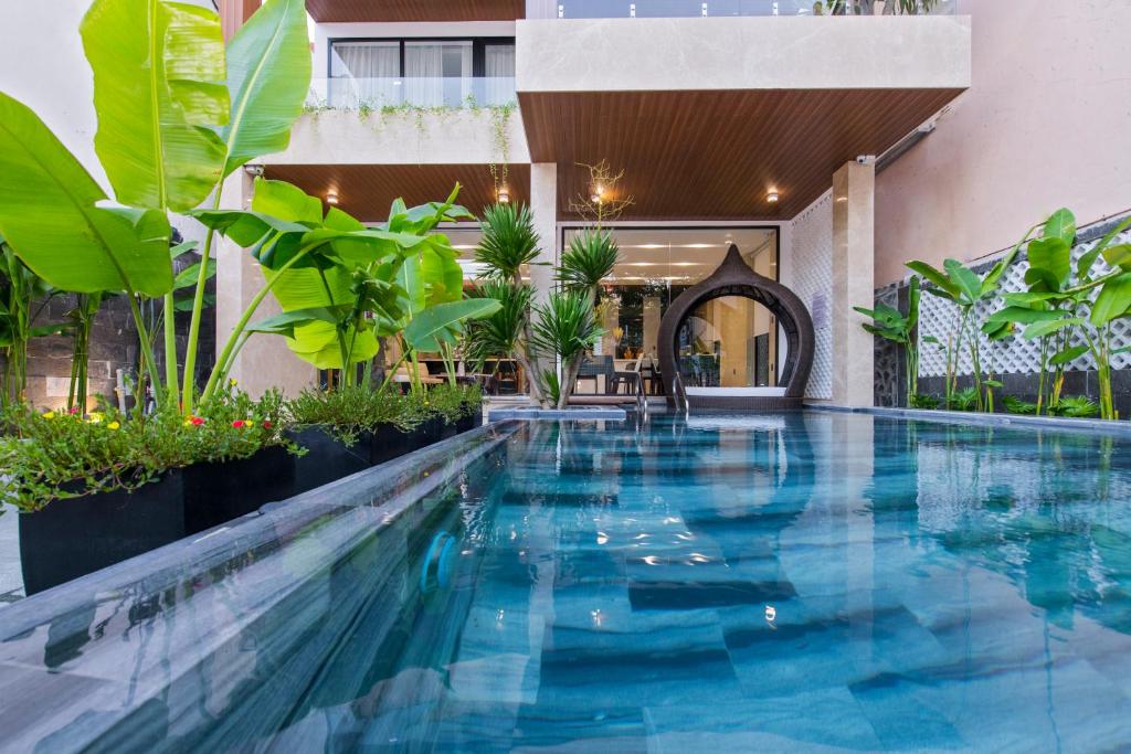 a swimming pool in the middle of a building with plants at Khong Cam Garden Villas in Hoi An