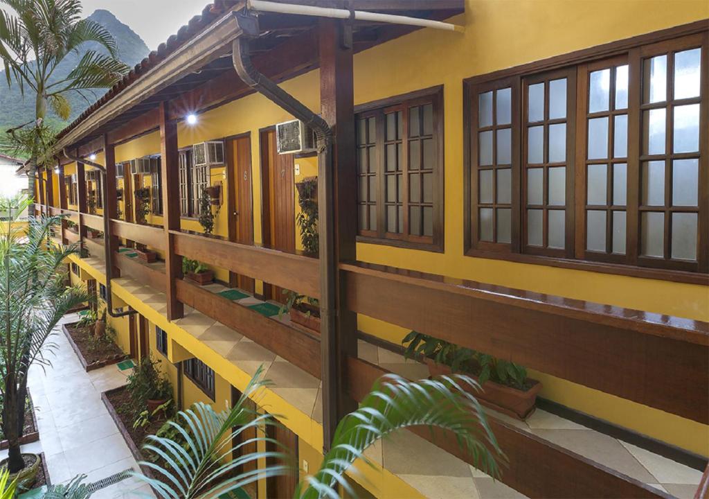 a yellow building with windows and plants at Lonier Praia Inn Flats in Abraão