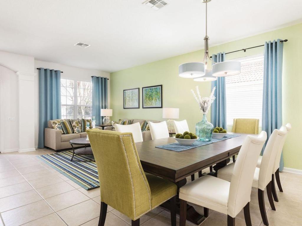 comedor y sala de estar con mesa y sillas en Windsor Hills 6 Bedrooms Pool Villa, 2.5 miles to Disney - 2540HS, en Orlando