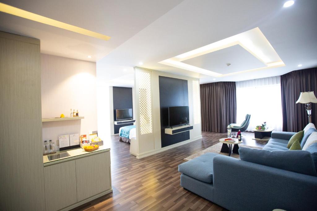 een woonkamer met een blauwe bank en een tv bij Central Hotel Thanh Hoa in Thanh Hóa