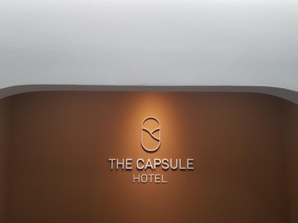 um sinal que diz o hotel cápsula em um fundo marrom em THE CAPSULE Myeongdong em Seul
