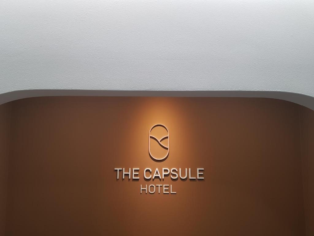 ein Schild, auf dem steht, das Kapselhotel auf braunem Hintergrund in der Unterkunft THE CAPSULE Myeongdong in Seoul