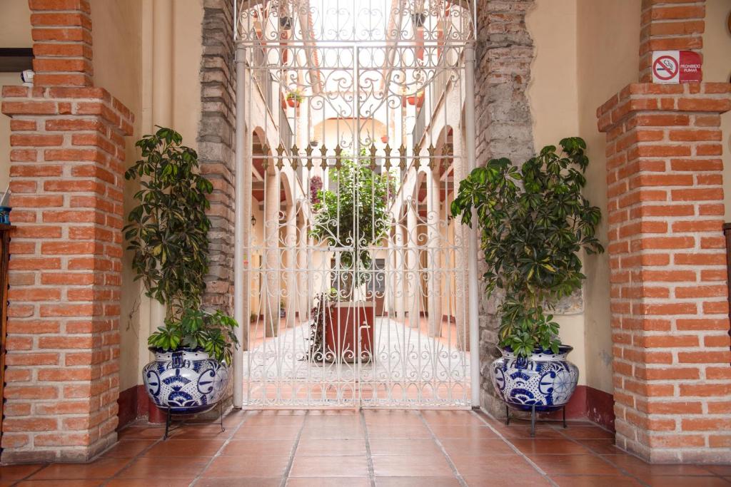 ein Tor in einem Gebäude mit zwei Topfpflanzen in der Unterkunft Hotel Rincón Poblano in Puebla