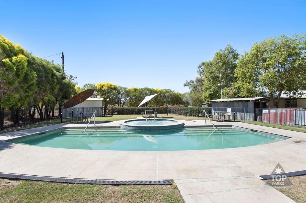 a swimming pool with a fountain in a yard at Goondiwindi Holiday Park in Goondiwindi