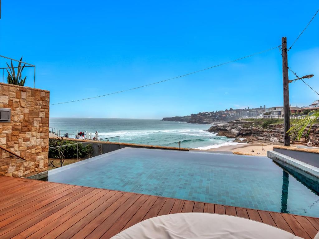 a swimming pool on a deck with a view of the beach at Tamarama Apartments in Sydney