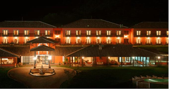 un grand bâtiment avec des lumières devant lui la nuit dans l'établissement Hotel Fazenda Jecava, à Teresópolis