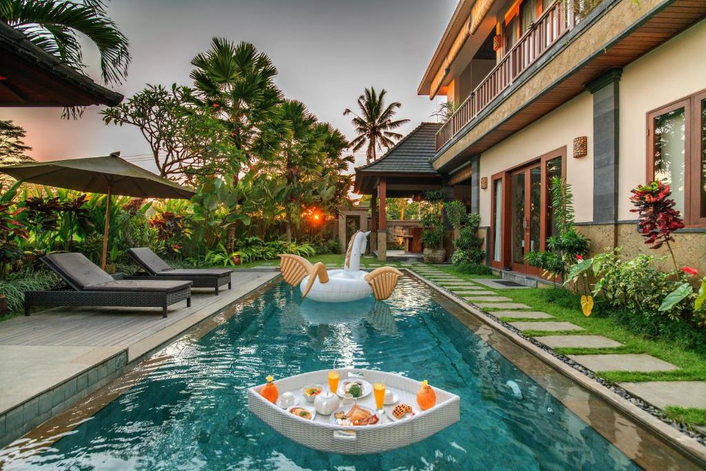ein Pool mit einem Boot in der Mitte eines Hauses in der Unterkunft Alosta Luxury Private Villa in Ubud