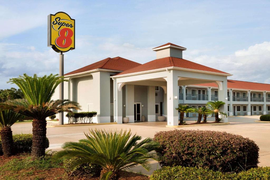 Un hotel con un cartel delante de un edificio. en Super 8 by Wyndham Lake Charles Northeast, en Lake Charles