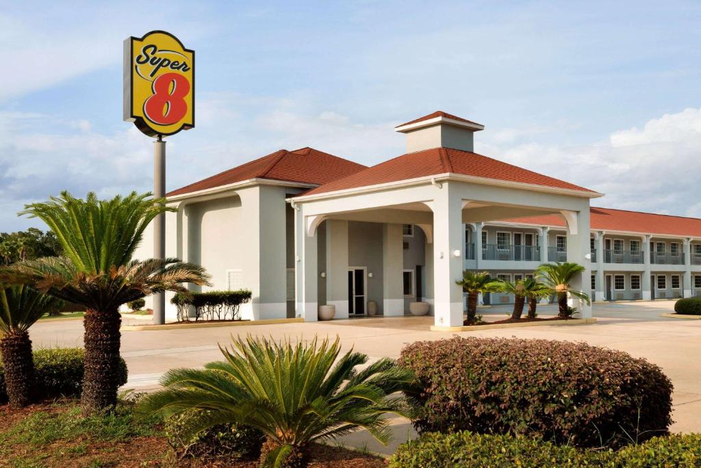 un hotel con un cartello di fronte a un edificio di Super 8 by Wyndham Lake Charles Northeast a Lake Charles