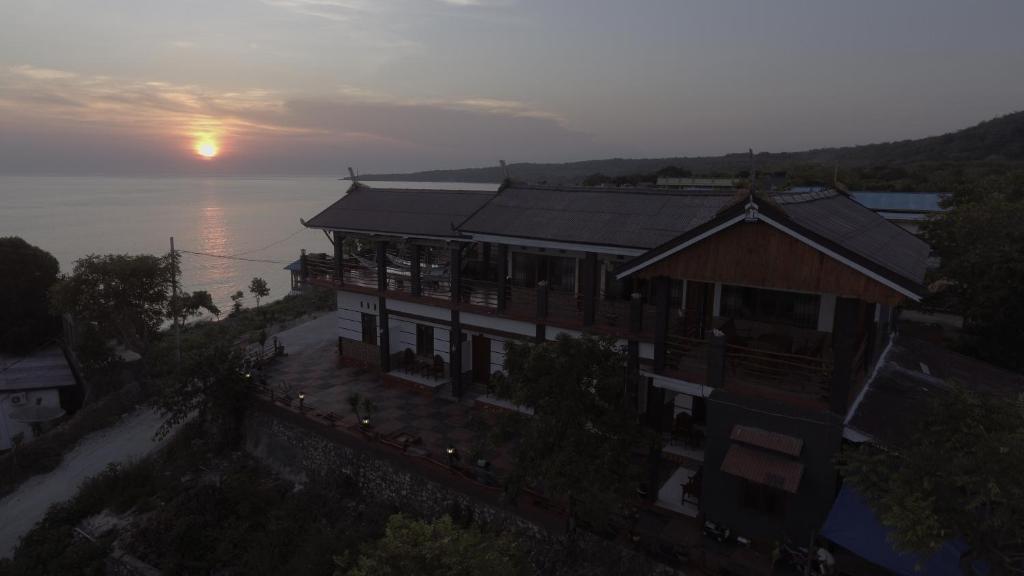 una vista aerea di un edificio con il tramonto sullo sfondo di Bira Panda Beach 2 a Bira