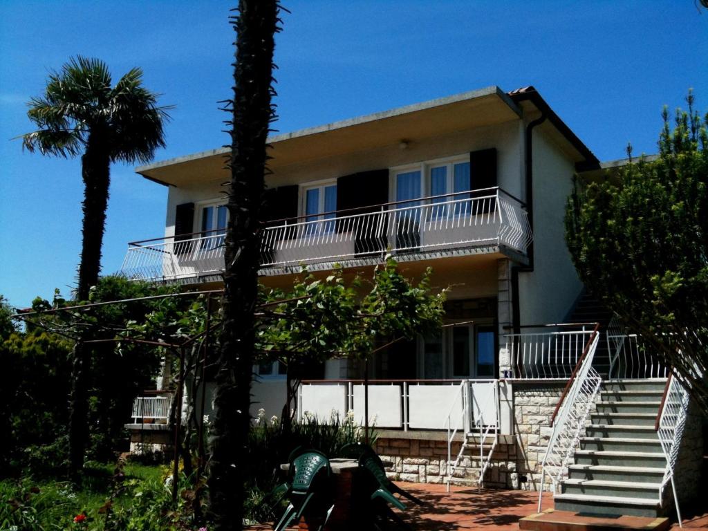 a house with stairs and a palm tree at Accommodation Vitalio in Umag