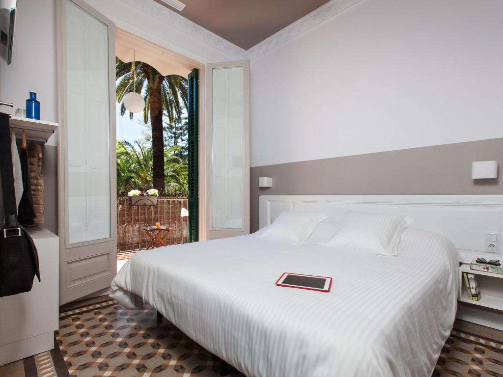 Un dormitorio con una cama blanca y una bandeja roja. en Ecozentric, en Barcelona