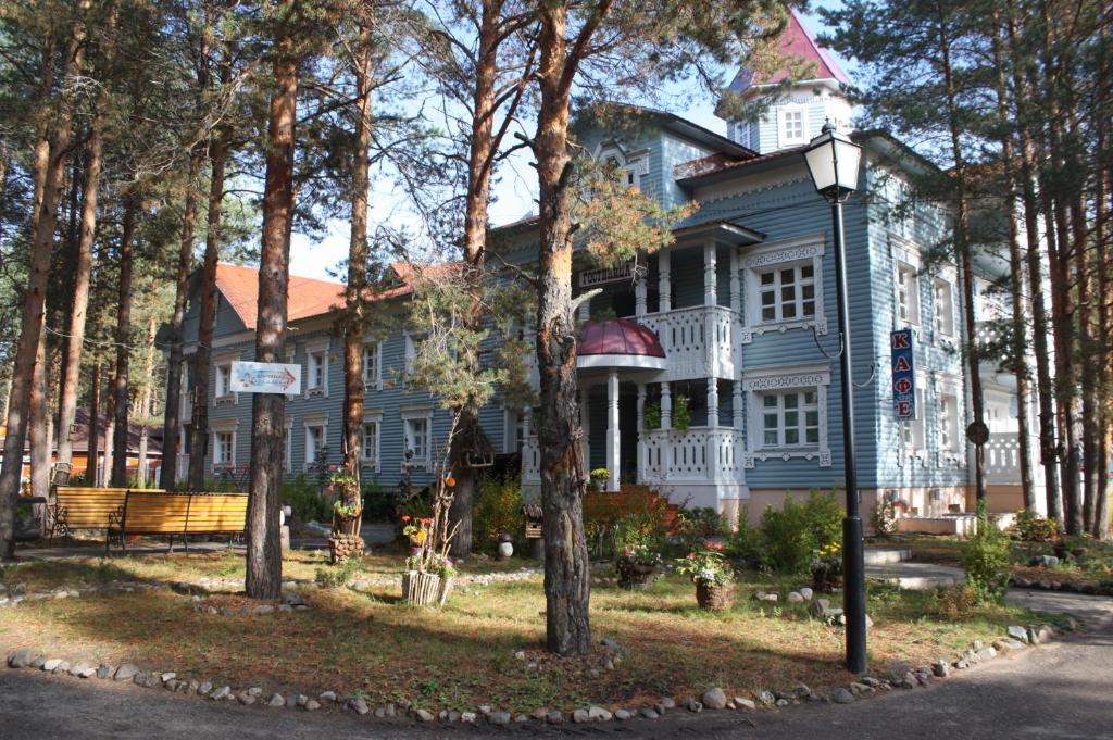 a large blue house with a tree at Hotel in Votchina Deda Moroza in Velikiy Ustyug