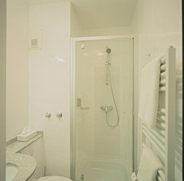 a white bathroom with a shower and a toilet at Hotel Diamant in Wedel