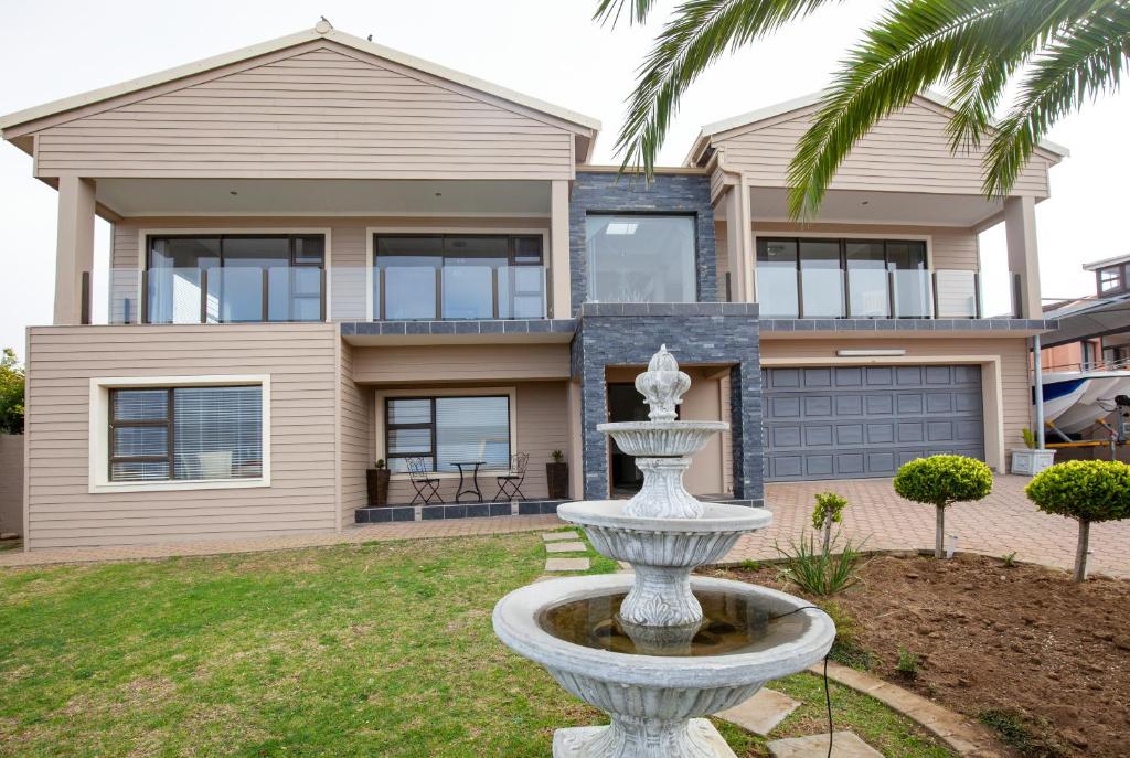 a house with a fountain in front of a house at JoJo's BnB in Mossel Bay