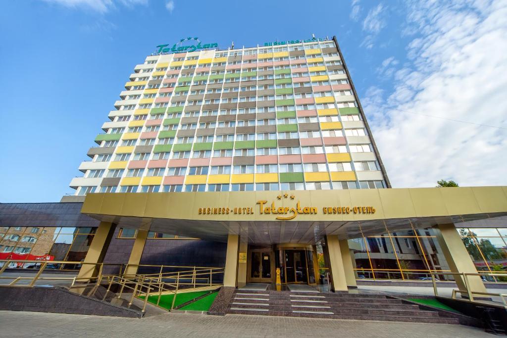 un edificio alto con una escalera delante en Tatarstan Business-Hotel en Naberezhnye Chelny