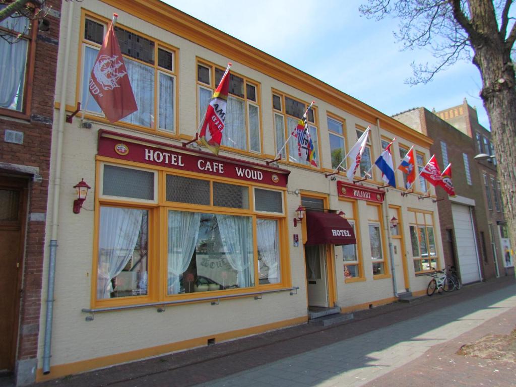 a hotel cafe with flags in front of a building at Hotel Cafe Woud in Den Helder