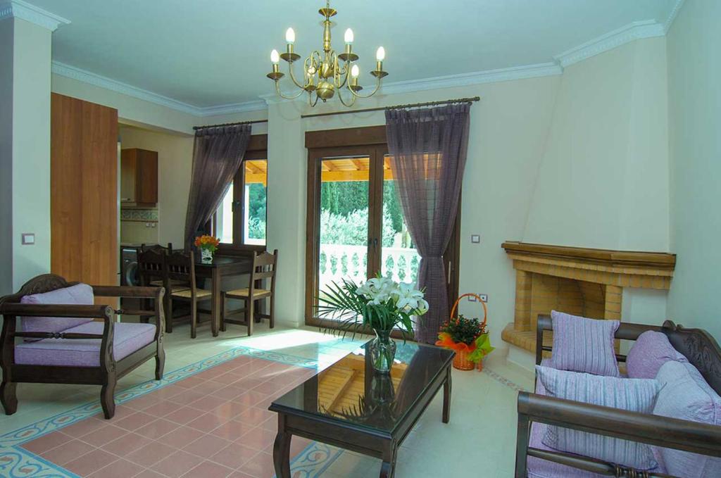 a living room with a fireplace and a dining room at Kerveli Luxury Villa in Kerveli